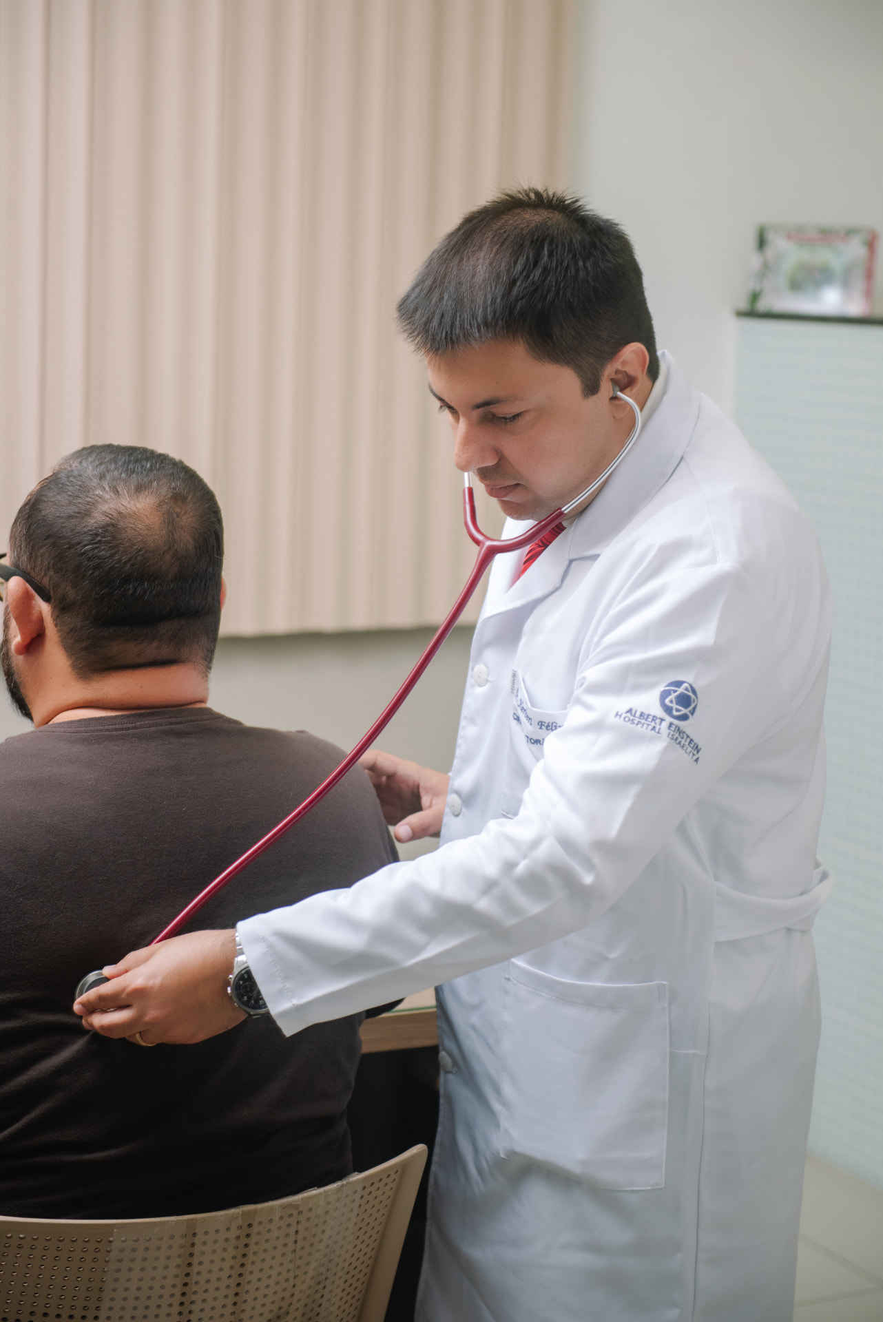 Dr. Herbert Félix auscultando um paciente durante consulta
